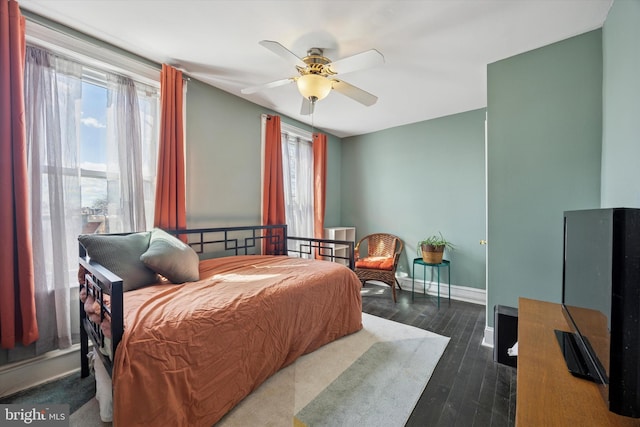 bedroom with baseboards, wood finished floors, and a ceiling fan