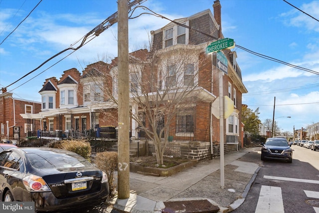 townhome / multi-family property with mansard roof and brick siding