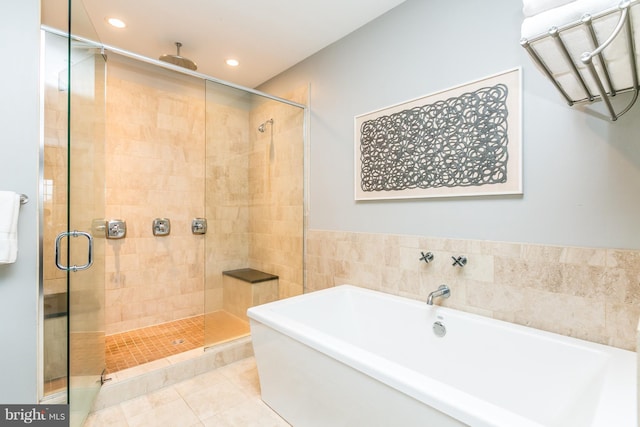 bathroom featuring tile patterned flooring, recessed lighting, a shower stall, and a freestanding tub