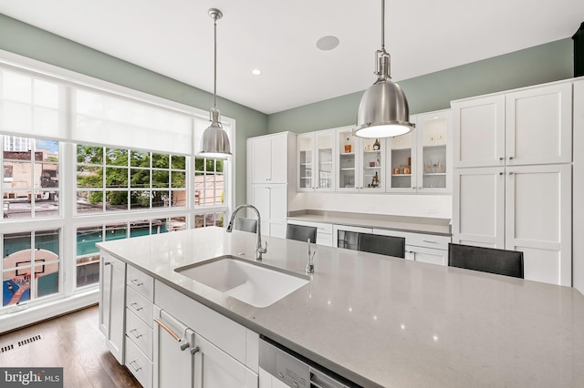 kitchen featuring a sink, visible vents, pendant lighting, and white cabinetry