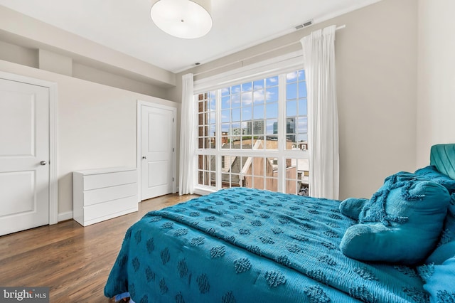 bedroom featuring visible vents and wood finished floors