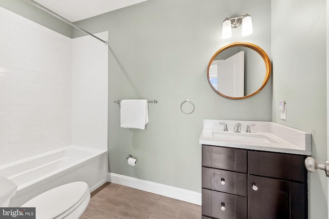 bathroom with baseboards, toilet,  shower combination, and vanity