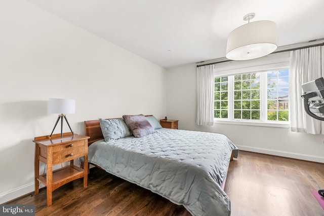 bedroom with baseboards and wood finished floors