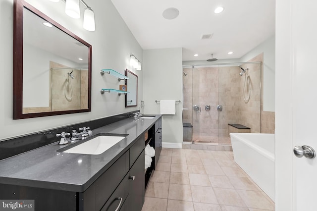 full bathroom featuring tile patterned floors, double vanity, a stall shower, and a sink