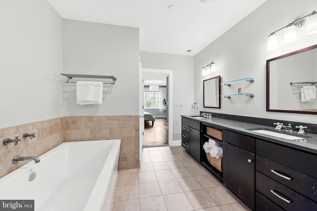 full bathroom with tile patterned floors, a bath, ensuite bathroom, and a sink