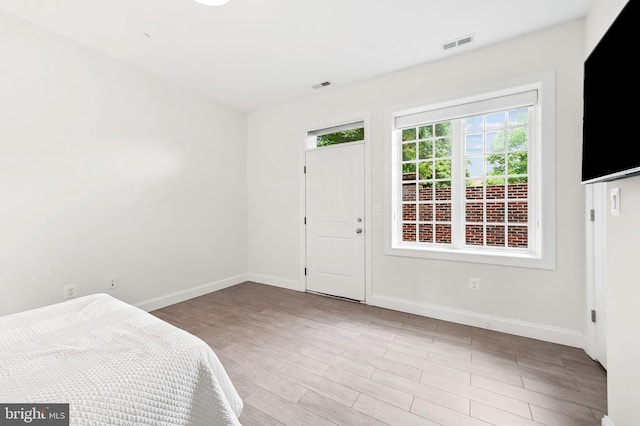 unfurnished bedroom with visible vents, baseboards, and wood finished floors