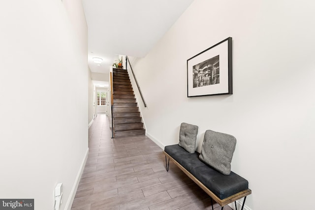 interior space with stairway, baseboards, and wood finished floors