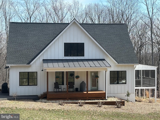 back of house featuring board and batten siding and a shingled roof