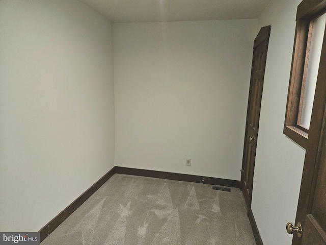 unfurnished room with visible vents, baseboards, and carpet