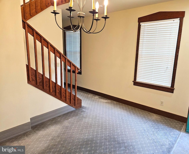 interior space featuring stairway, carpet, baseboards, and a chandelier