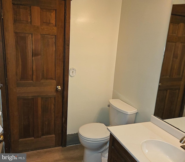 bathroom featuring vanity, toilet, and wood finished floors