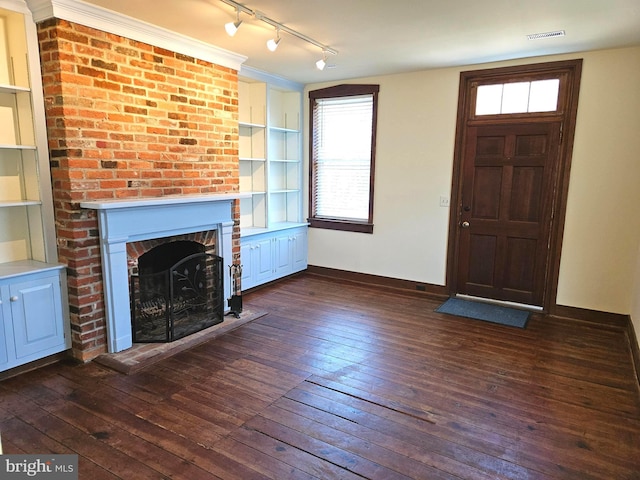 unfurnished living room featuring dark wood finished floors, visible vents, a fireplace, and baseboards