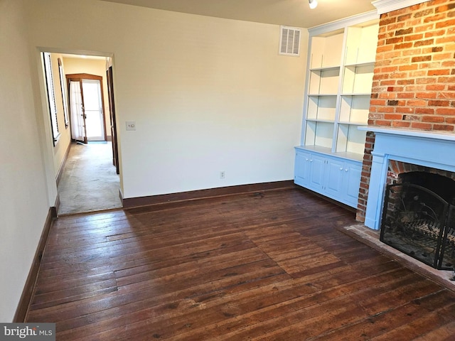 unfurnished living room featuring dark wood finished floors, a fireplace, visible vents, and baseboards