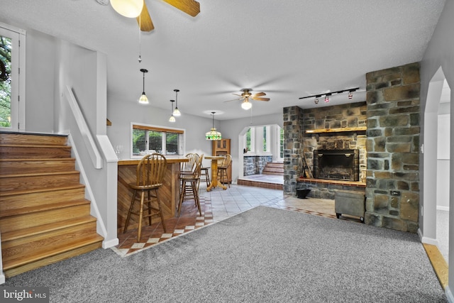 8359 Elm Rd, Millersville, MD 21108 - living room featuring a ceiling fan, stairway, a textured ceiling, bar, and a fireplace