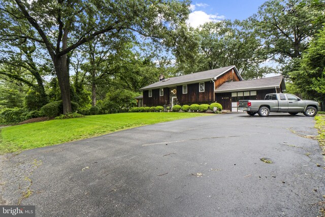 8359 Elm Rd, Millersville, MD 21108 - view of front of property with driveway, an attached garage, a front yard, and a chimney