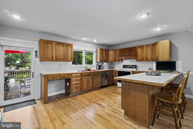 8359 Elm Rd, Millersville, MD 21108 - kitchen with range with electric stovetop, stainless steel dishwasher, a peninsula, tile counters, and brown cabinets
