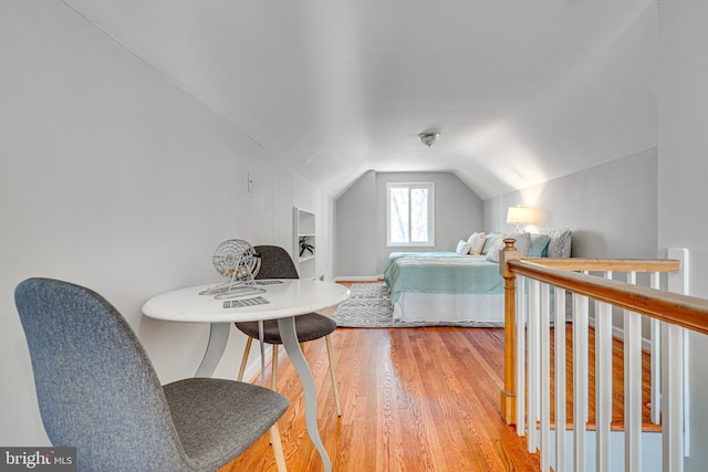 bedroom with lofted ceiling and light wood-style floors