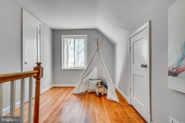 playroom with vaulted ceiling, baseboards, and wood finished floors