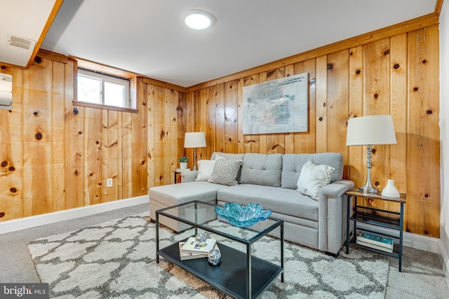 carpeted living area with wooden walls, baseboards, and visible vents