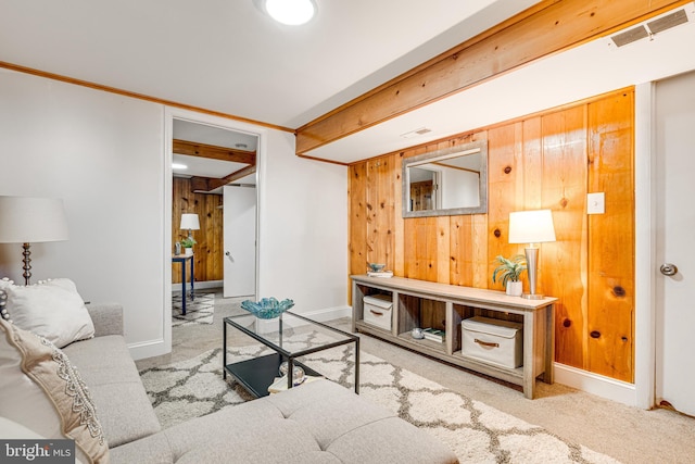 living room featuring wooden walls, carpet flooring, baseboards, and visible vents