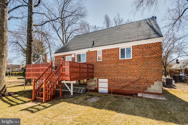 rear view of house featuring a deck, stairway, a lawn, and brick siding