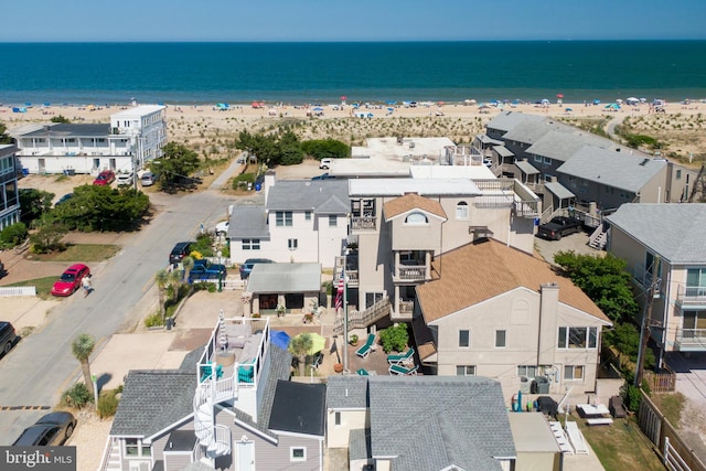 drone / aerial view with a residential view, a view of the beach, and a water view