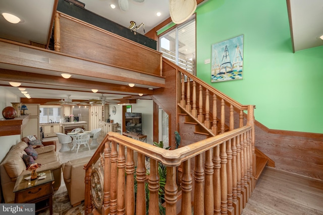 staircase with baseboards, wood finished floors, and a ceiling fan