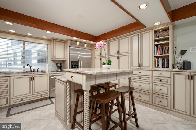 kitchen with light tile patterned floors, recessed lighting, cream cabinets, and built in refrigerator