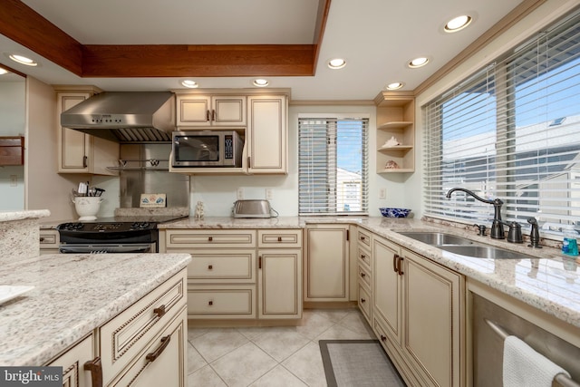 kitchen featuring a sink, cream cabinetry, range with electric stovetop, stainless steel microwave, and exhaust hood