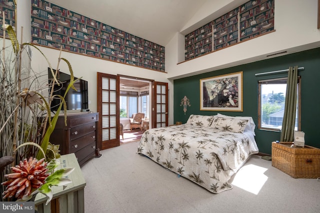 bedroom featuring multiple windows, french doors, high vaulted ceiling, and carpet floors