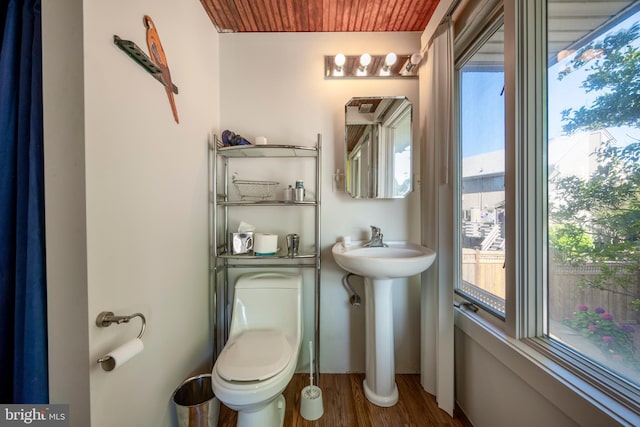 half bath with toilet and wood finished floors