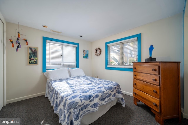 carpeted bedroom with multiple windows, baseboards, and visible vents