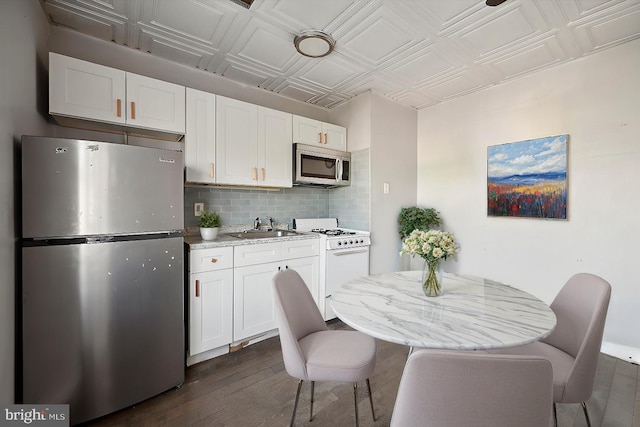 kitchen with white cabinets, an ornate ceiling, tasteful backsplash, and appliances with stainless steel finishes