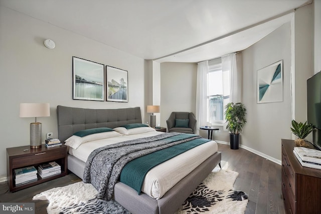 bedroom with baseboards and dark wood finished floors