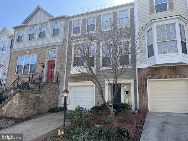 townhome / multi-family property featuring brick siding, concrete driveway, and an attached garage