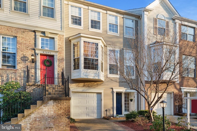 multi unit property with brick siding and a garage