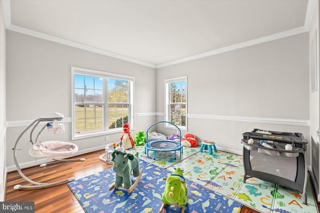 game room featuring baseboards, wood finished floors, and ornamental molding