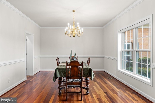 dining room featuring an inviting chandelier, baseboards, wood-type flooring, and ornamental molding