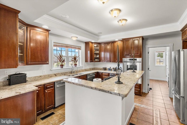 kitchen featuring a sink, a kitchen island, appliances with stainless steel finishes, and a healthy amount of sunlight