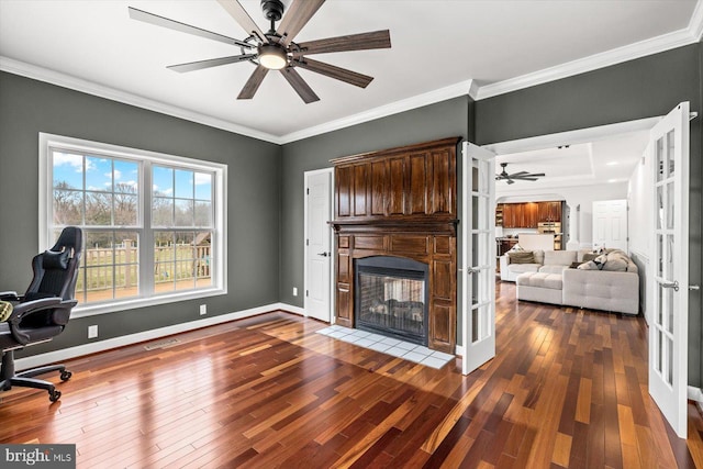 office space with hardwood / wood-style floors, a ceiling fan, baseboards, ornamental molding, and french doors