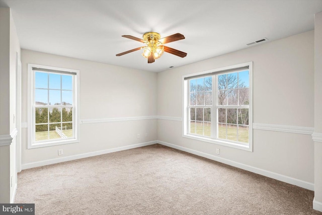 spare room featuring visible vents, carpet flooring, baseboards, and ceiling fan