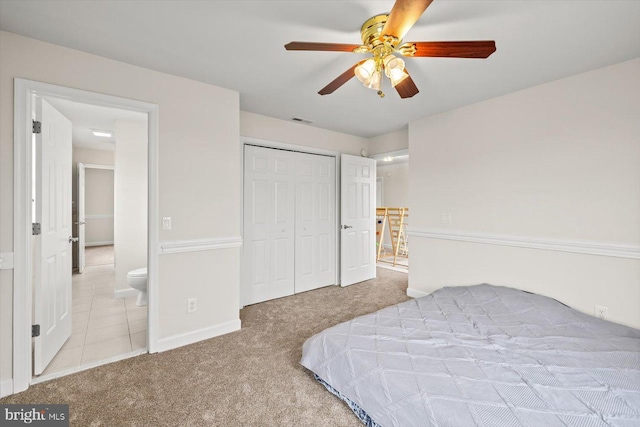 carpeted bedroom with visible vents, baseboards, a closet, and ceiling fan