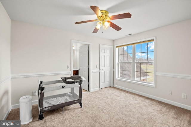 interior space featuring visible vents, baseboards, ceiling fan, and carpet floors