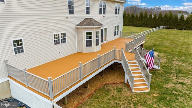 back of property featuring stairway, a lawn, and a wooden deck