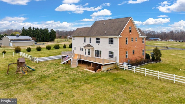 back of property with stairway, a lawn, a deck, and fence