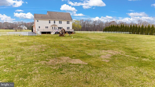 view of yard with a rural view, fence, and a wooden deck