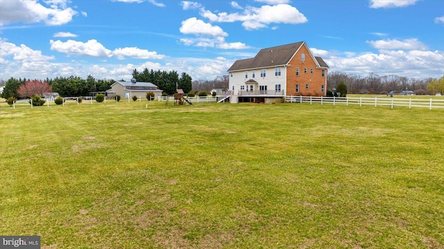 view of yard with a rural view and fence