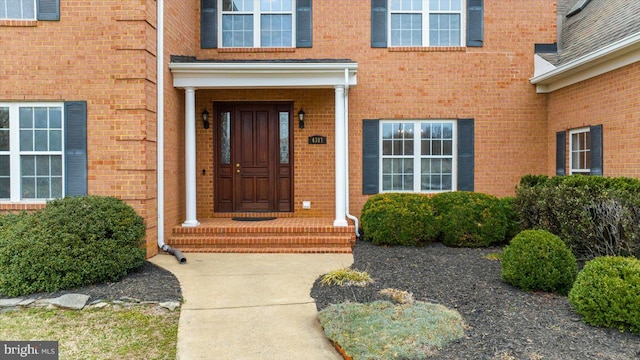 property entrance featuring brick siding