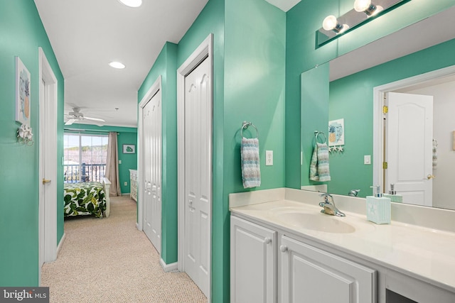 bathroom with recessed lighting, baseboards, ceiling fan, and vanity