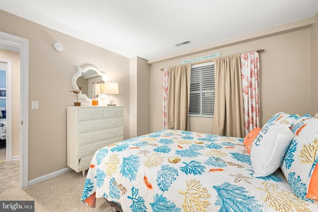 bedroom featuring visible vents, baseboards, and light colored carpet